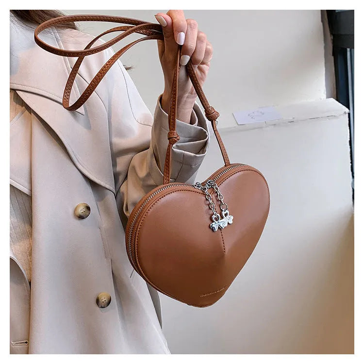 Women's heart-shaped PU crossbody bag in milky white with single shoulder strap and sandwich pocket