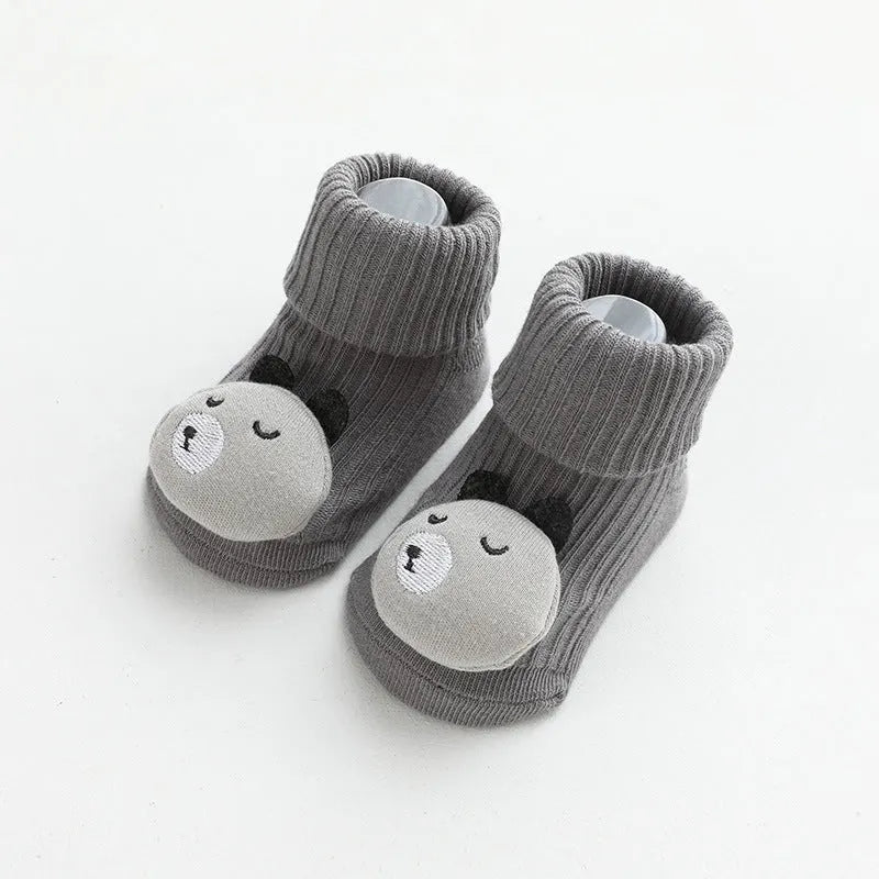 Baby socks with non-slip rubber grip soles on the feet, shown in a light grey colour.