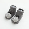 Baby socks with non-slip rubber grip soles on the feet, shown in a light grey colour.