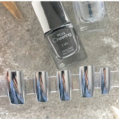Bottle of mirror silver nail polish with brush and stainless-steel ball for mixing