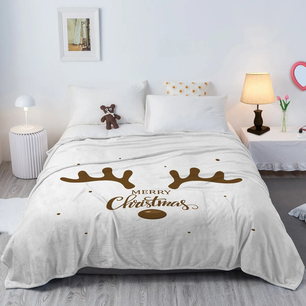 White flannel velvet deer antler pattern Christmas blanket on a sofa