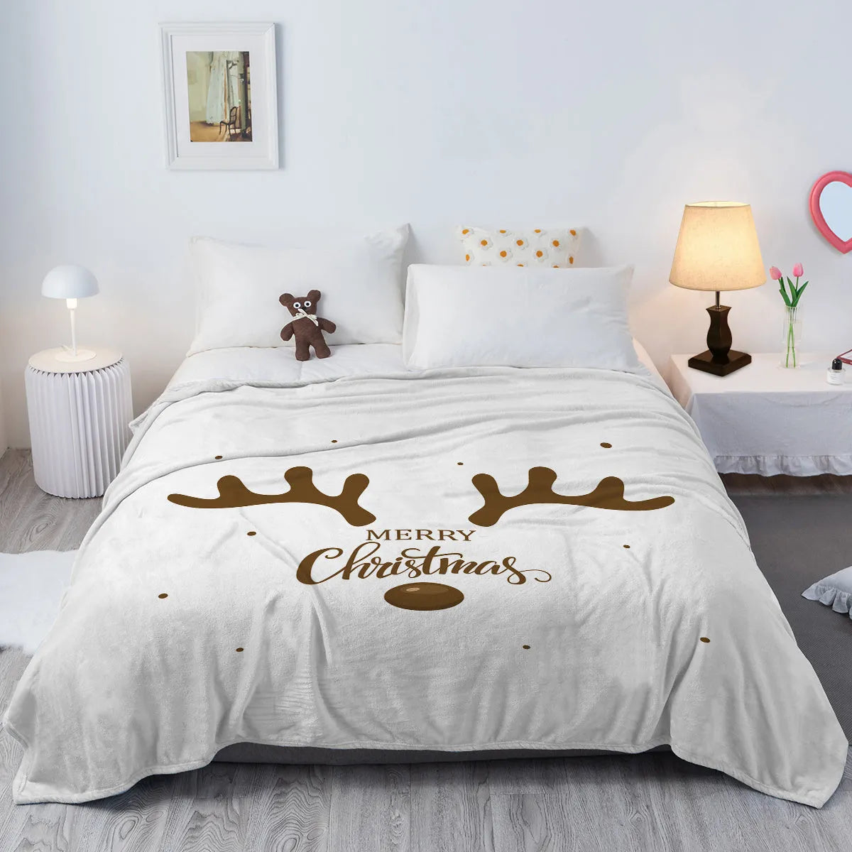 White flannel velvet deer antler pattern Christmas blanket on a sofa