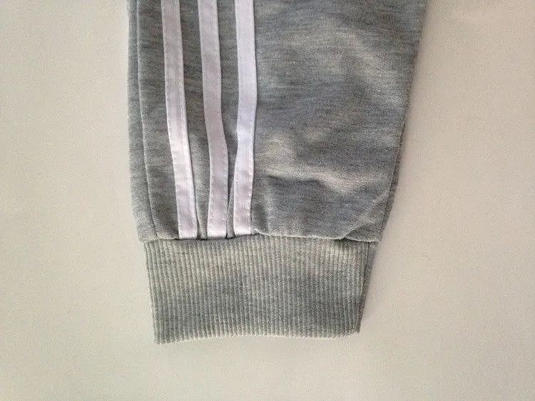 Men's straight leg cotton casual trousers with three-bar side stripe in grey, black, and navy