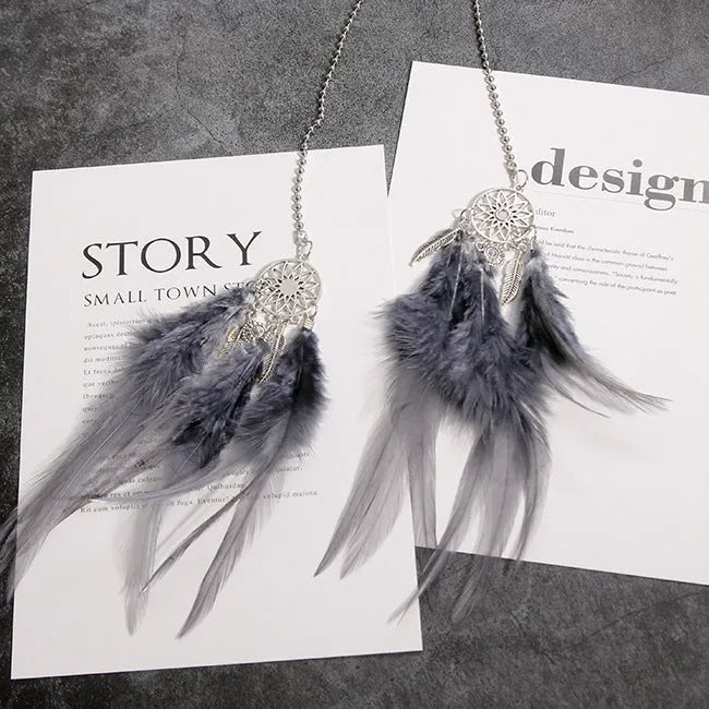 Dreamcatcher car ornament with metal frame and feather in one of six colours on car interior