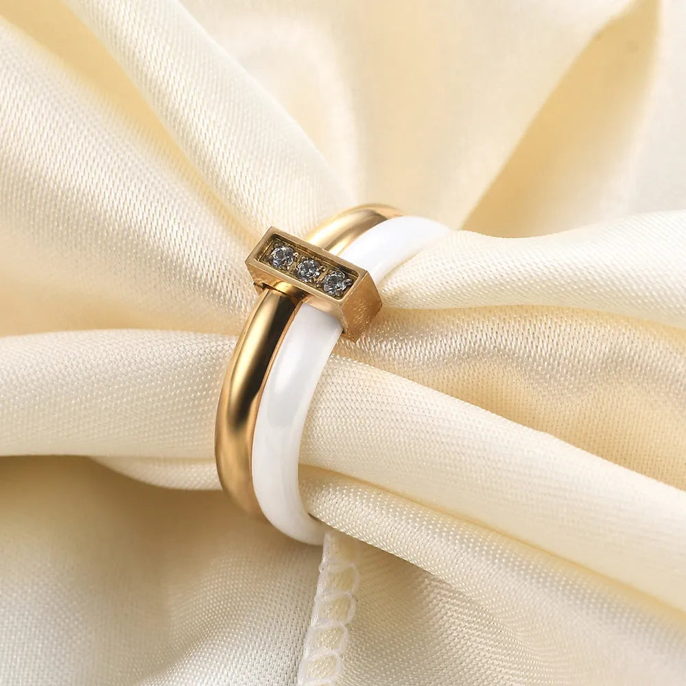Glossy black ceramic women's ring with silver stitch-inlaid zirconium detail on a geometric band.