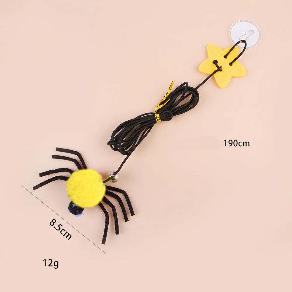 Red and yellow feather cat toy hanging from door on elastic rope with bell spider element for indoor feline play