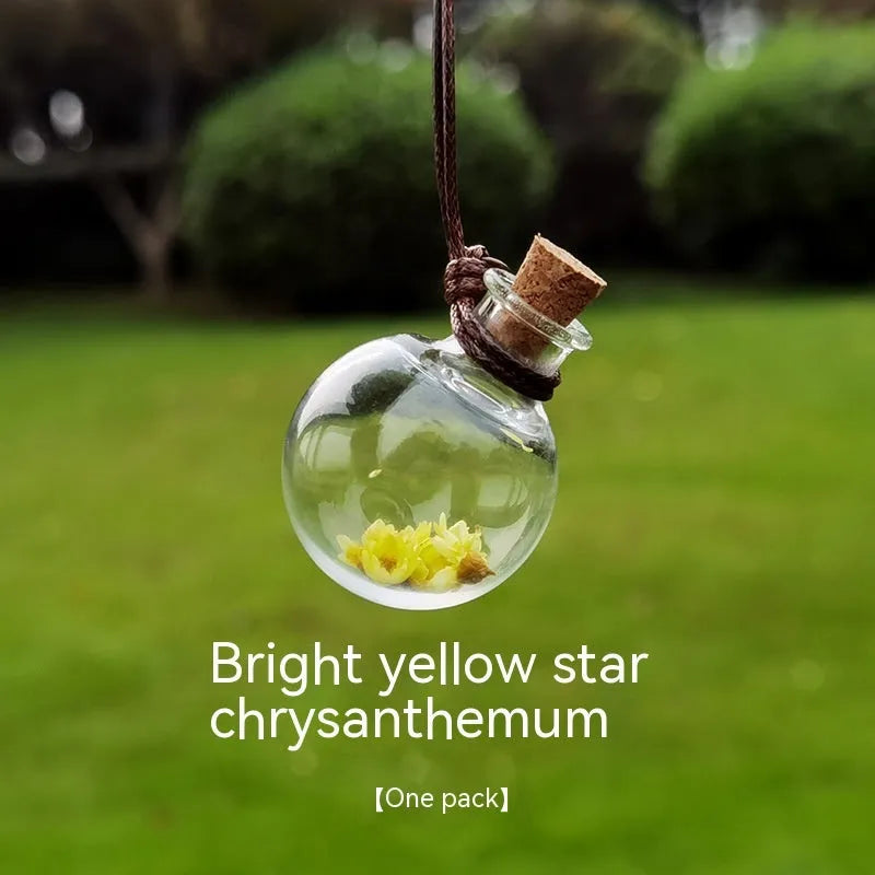 Glass car perfume pendant with preserved flower decoration hanging in car interior