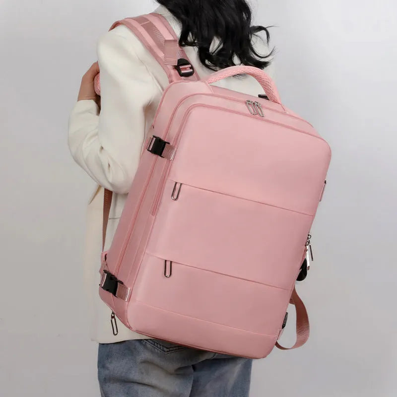 Large grey travel backpack for women with multiple compartments, shown open.