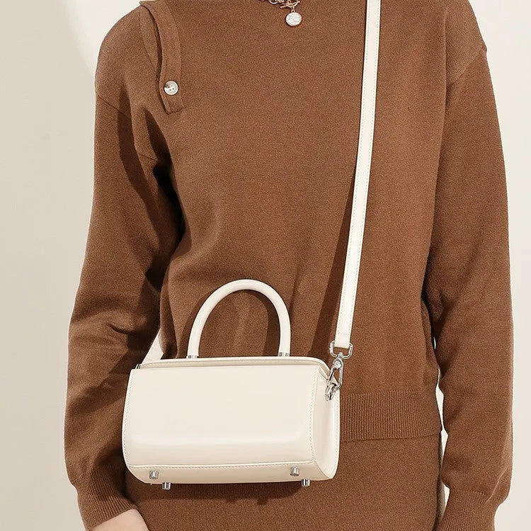 Women's leather crossbody bag in clamshell design showing internal phone and file pockets.