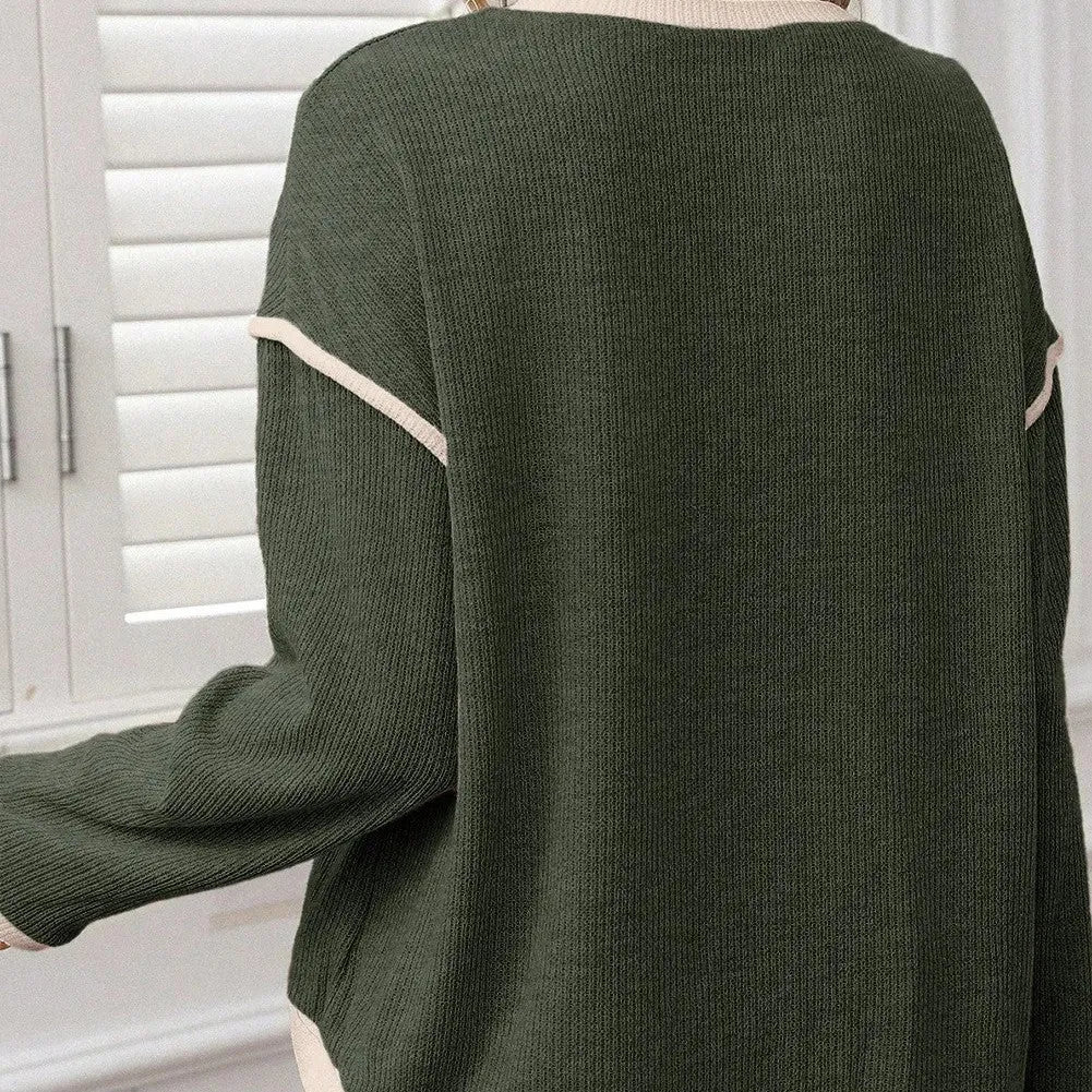 Women's beige knit top with green four leaf clover contrast trim on sleeves and neckline.