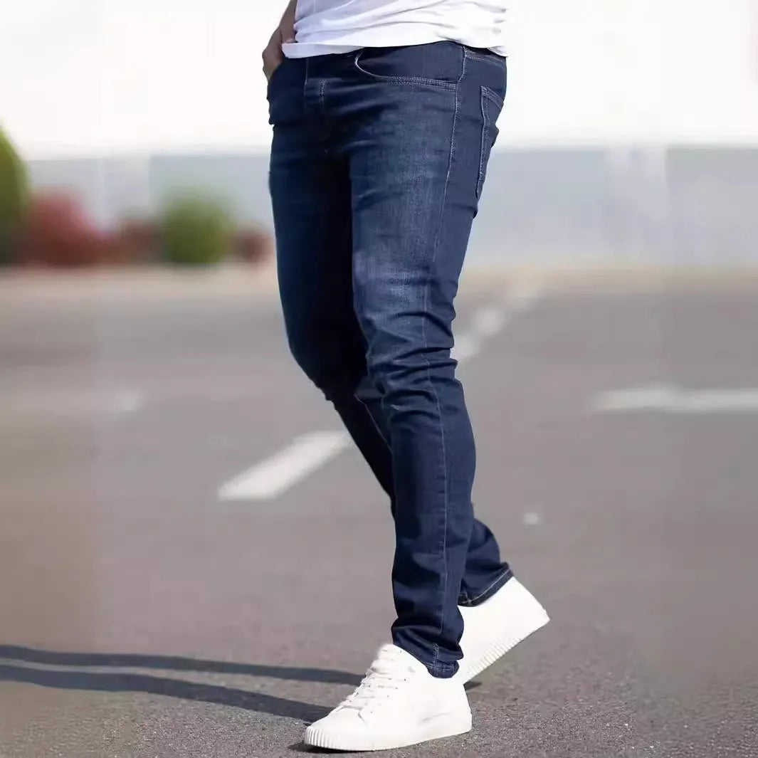 A man wearing dark blue slim fit casual jeans with an elastic waistband.