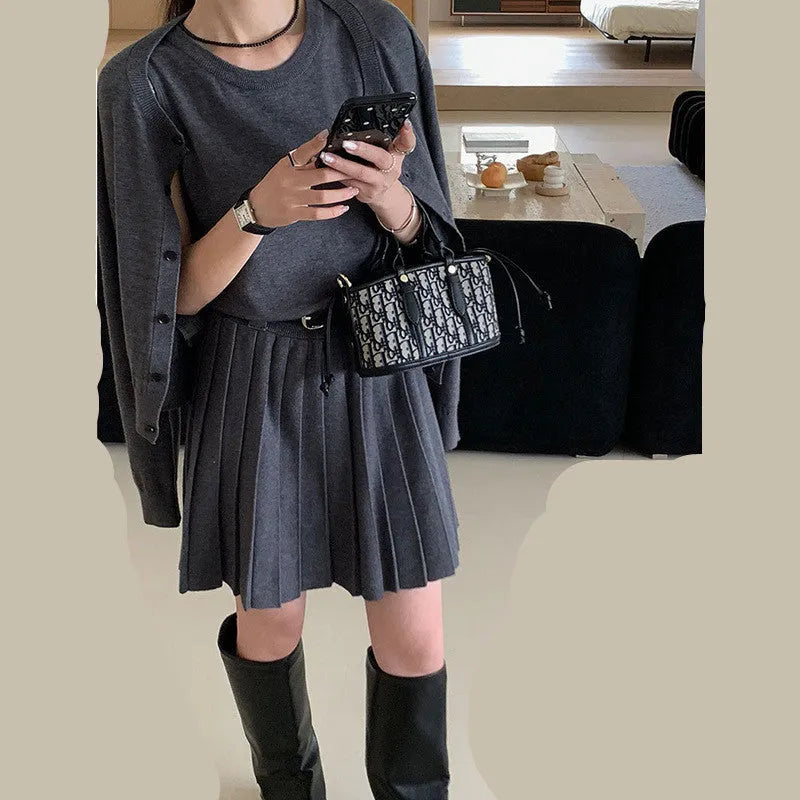 Grey knitted women's two-piece set with a pleated vest skirt and long-sleeved cardigan.