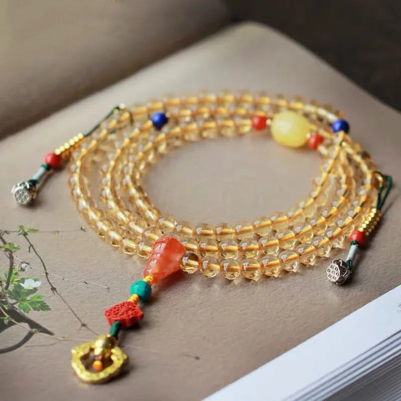 Yellow natural citrine bracelet with 1mm beads and filament accessory details on a wrist.