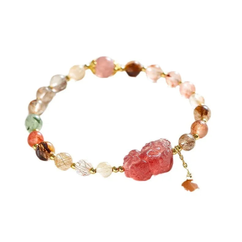 Copper women's bracelet with strawberry quartz crystal, Pixiu charm, and pearl accents on a white background.