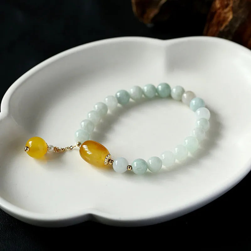 Women's ethnic style geometric bracelet with hanging agate tassel and 14K gilded details.