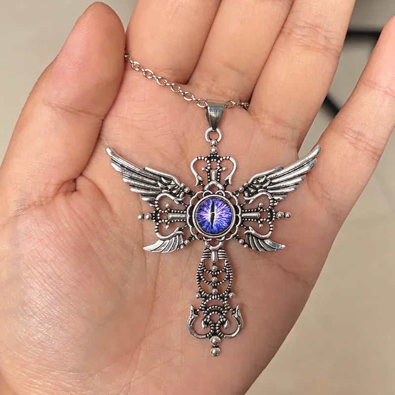 Close-up of a devil wings and cross design alloy pendant necklace on a chain, shown in a choice of colours.