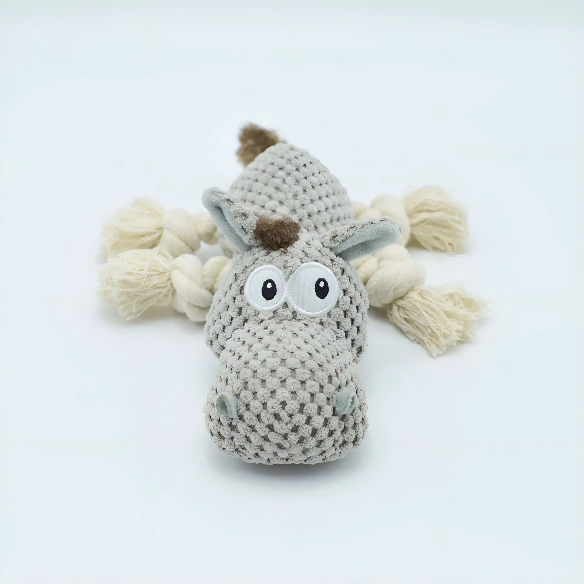 Grey plush donkey dog toy with creaking sound, showing size against a hand.