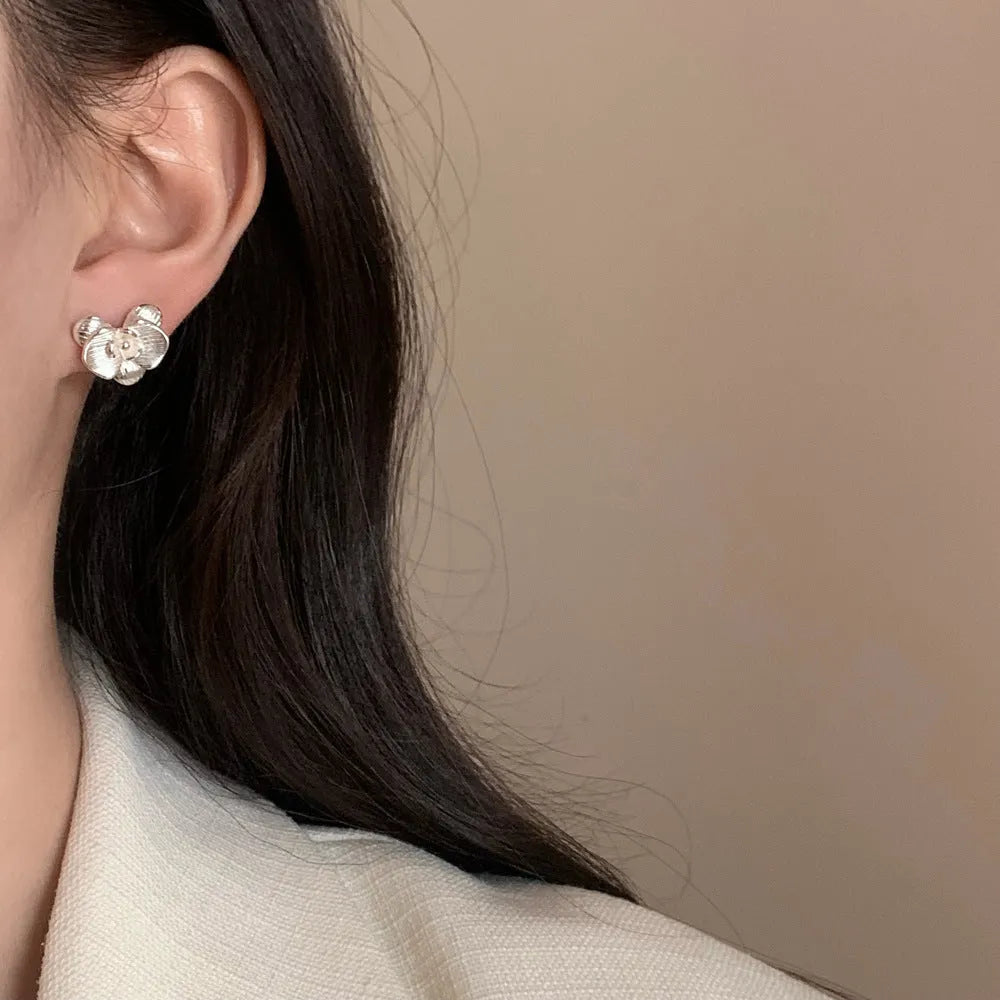 A pair of retro-style flower earrings with petal design, shown in gold electroplated finish.