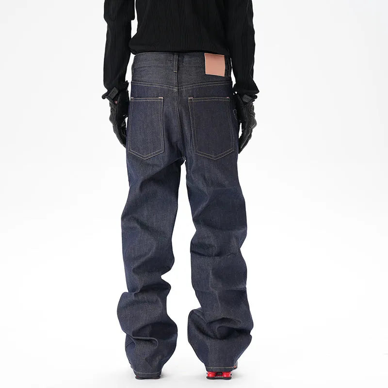 Man's dark blue loose-fit straight leg denim jeans on a neutral background.
