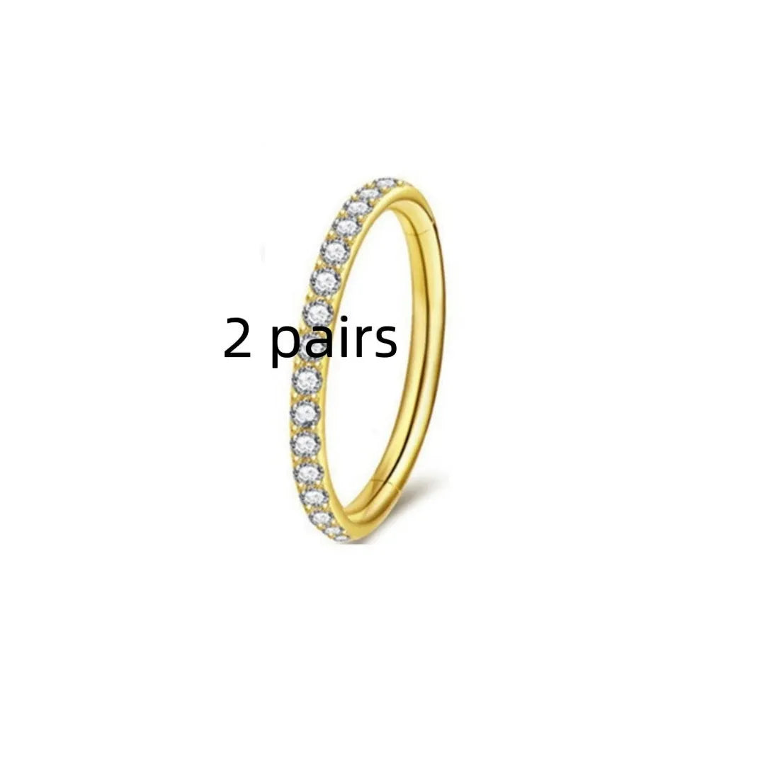 Close-up of a round, seamless stainless steel nose ring in a gold finish, showing its smooth, clasp-free design.