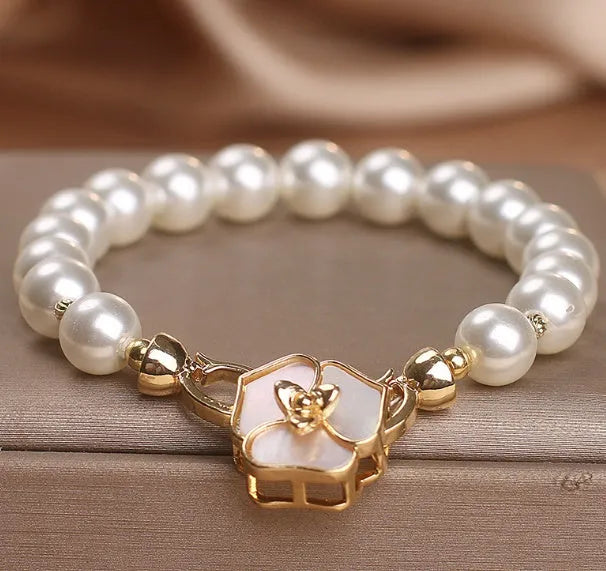 White imitation pearl bracelet with floral French-style design on display for women
