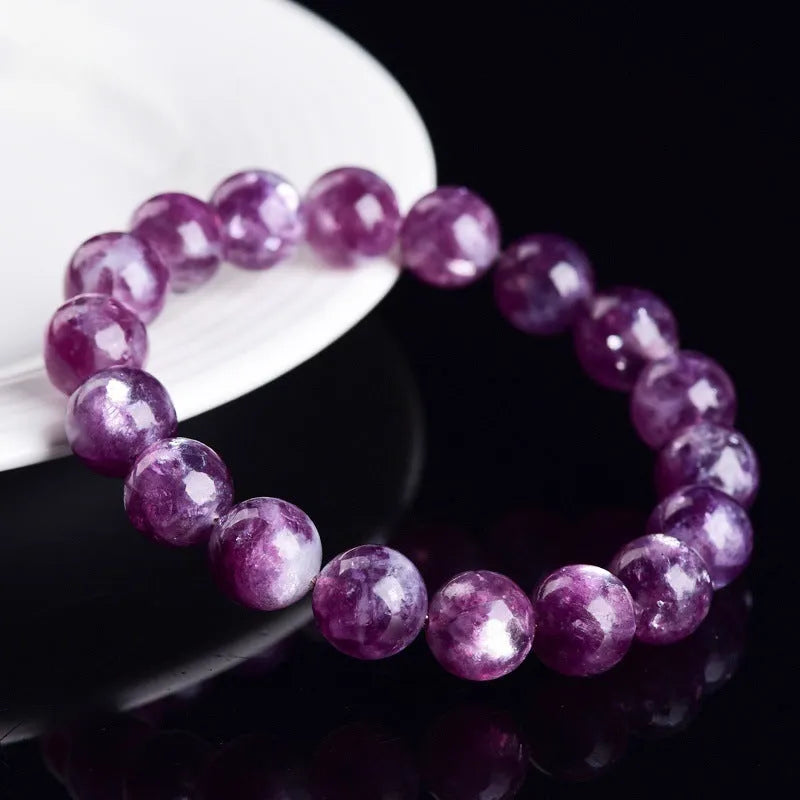 Polished geometric crystal bracelet in purple and pink hues on wrist.