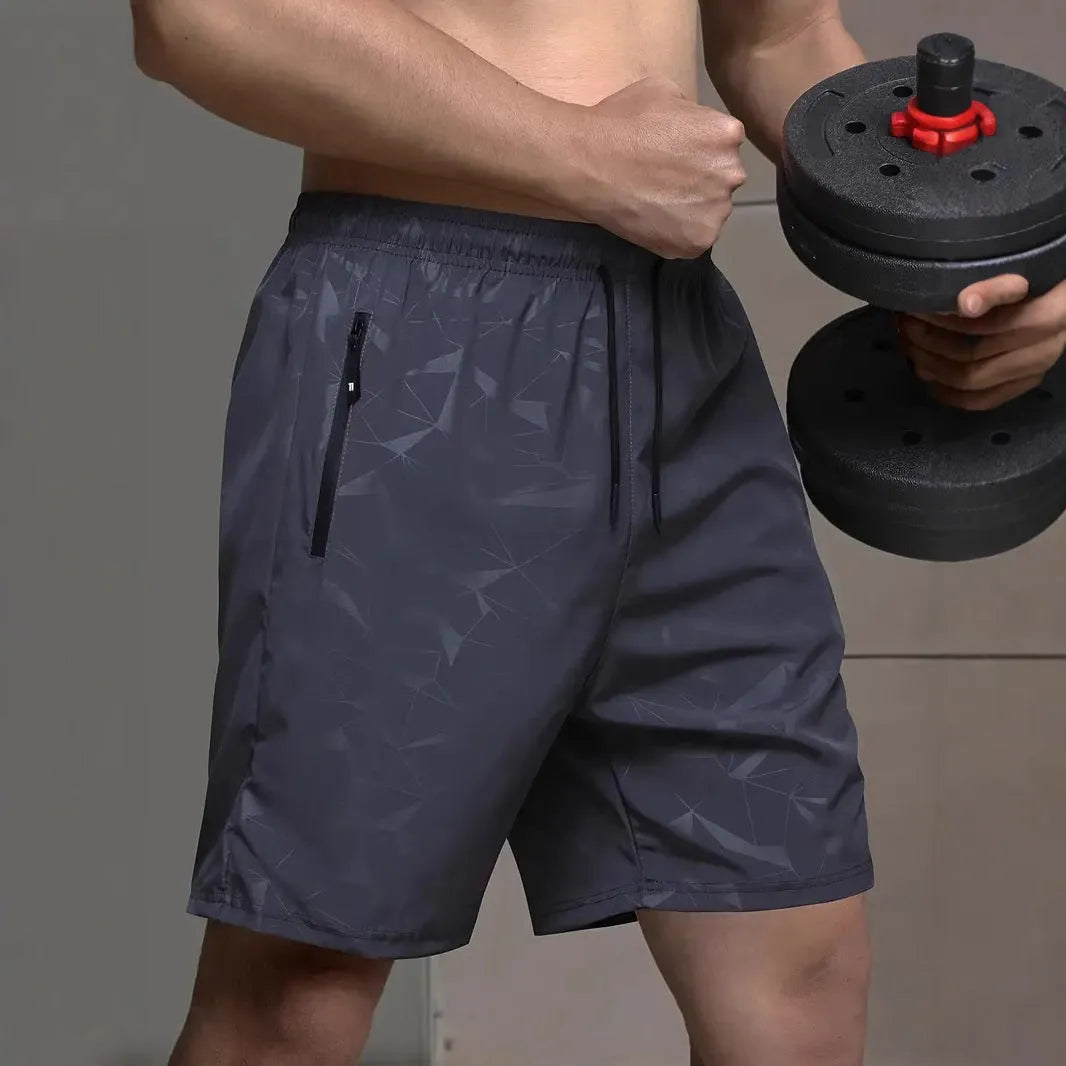 Man wearing loose fit black polyester sports shorts with elastic waistband
