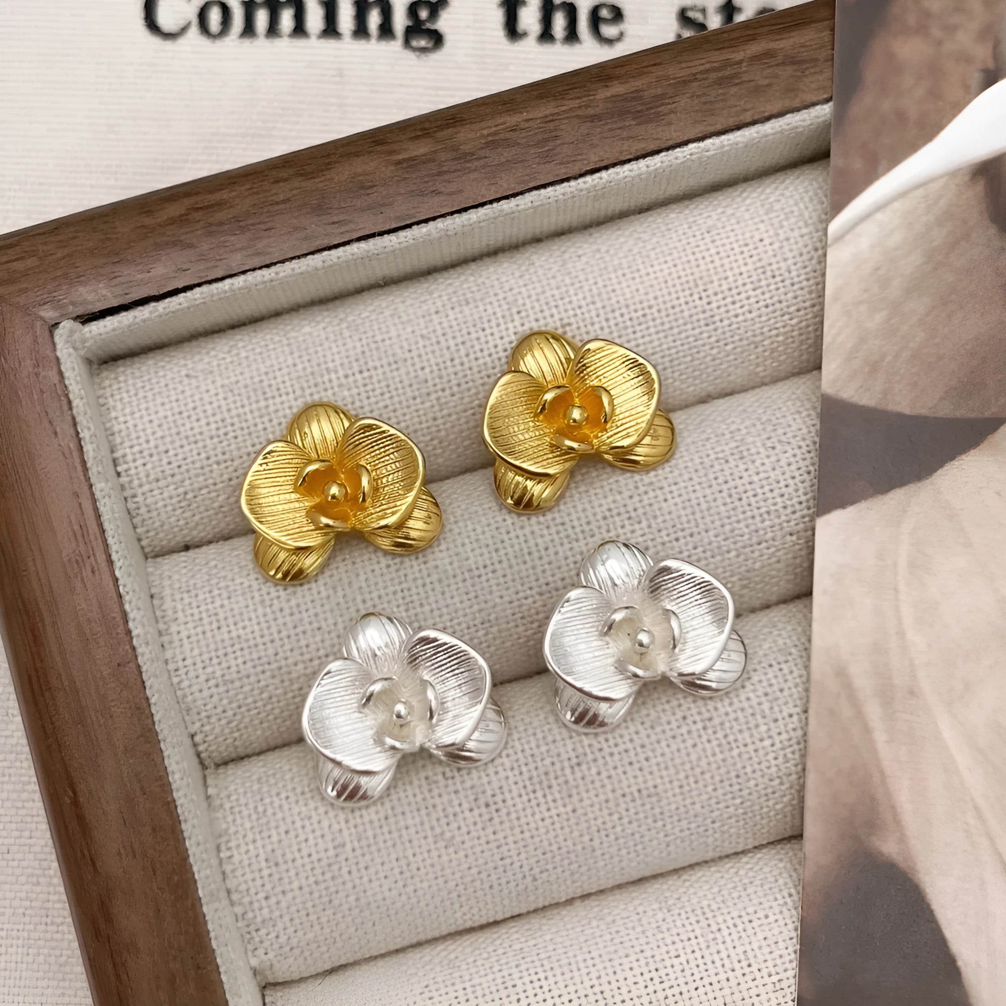 A pair of retro-style flower earrings with petal design, shown in gold electroplated finish.