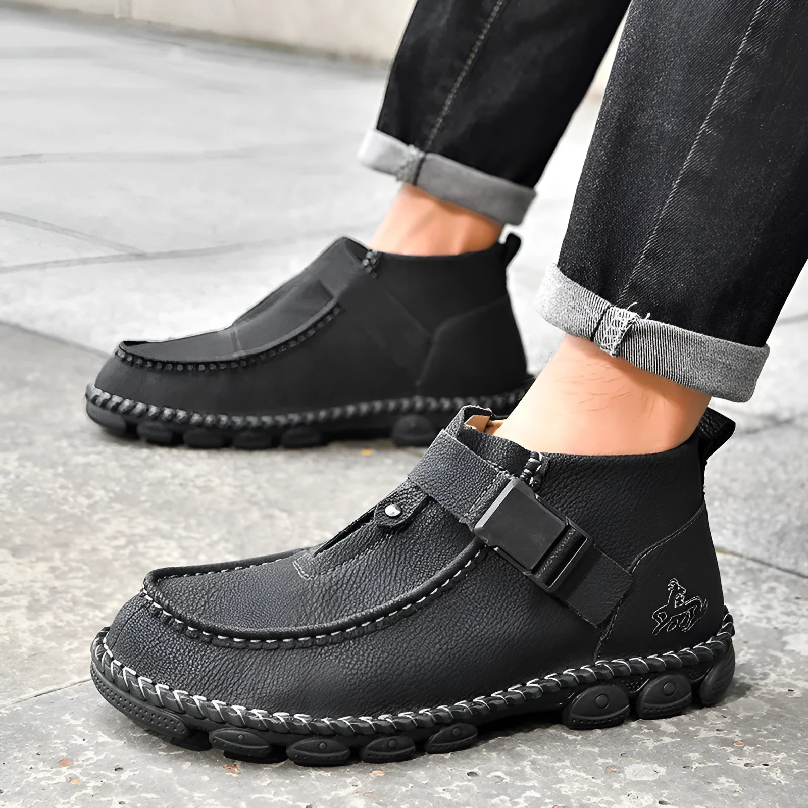 Casual flat slip-on shoes in black synthetic PU leather with visible handmade stitching around the sole.