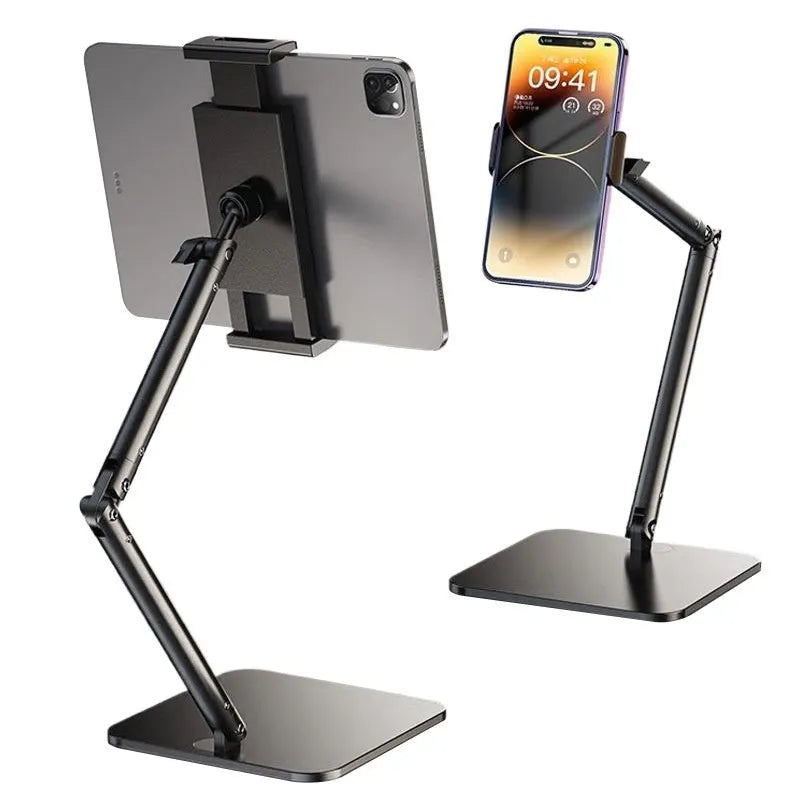 Silver alloy desktop phone and tablet bracket with double adjustable arms and a remote control on a wooden desk.