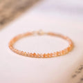 Close-up of a women's bracelet with small 3mm sunstone crystal beads on a wrist, showing its thin profile.