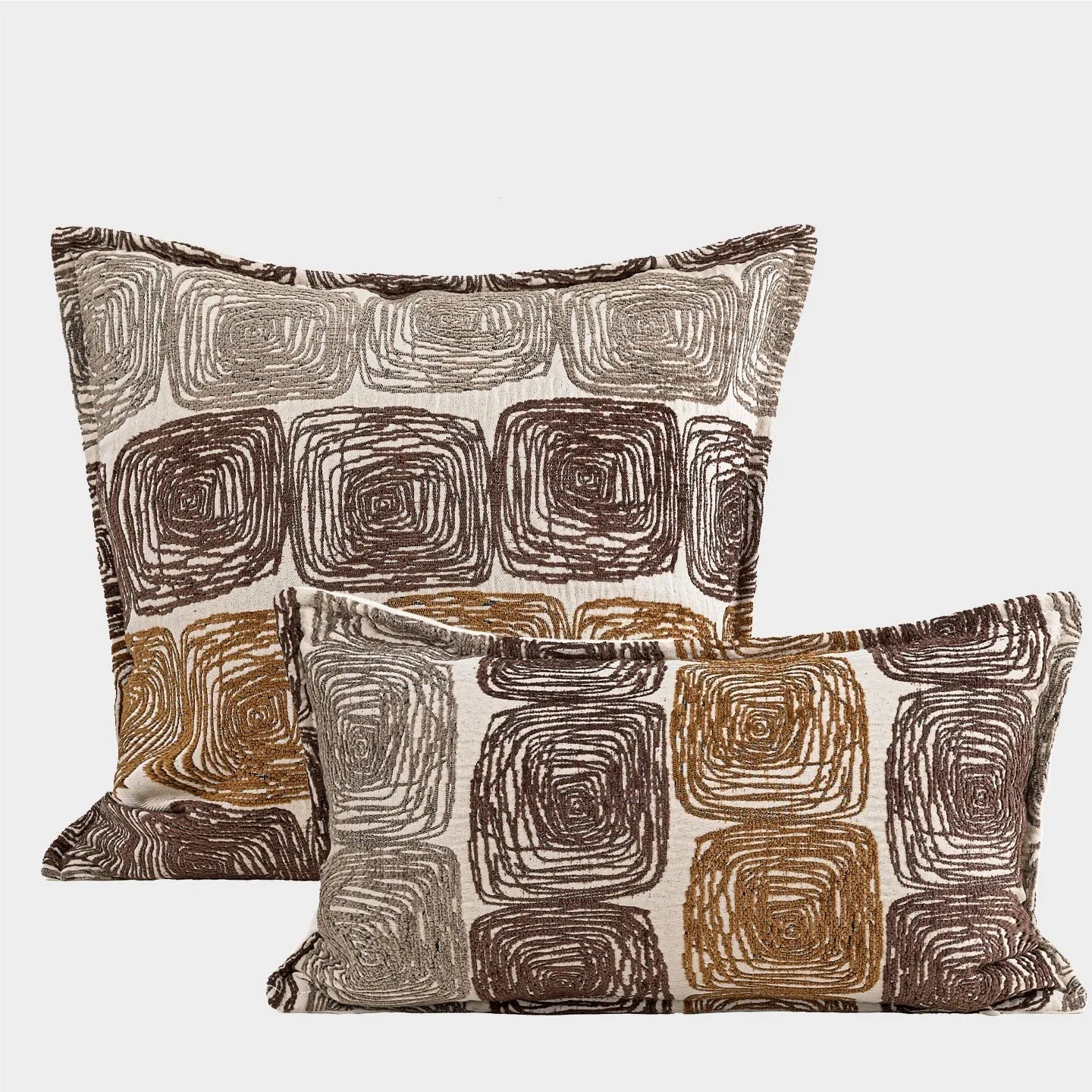 Square cream and coffee abstract coil pattern cushion cover on a grey sofa