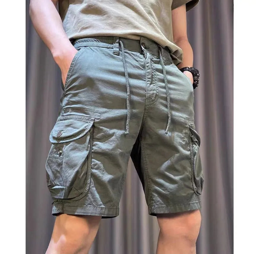 Loose straight-leg multi-pocket casual overalls trousers in khaki colour on a hanger.