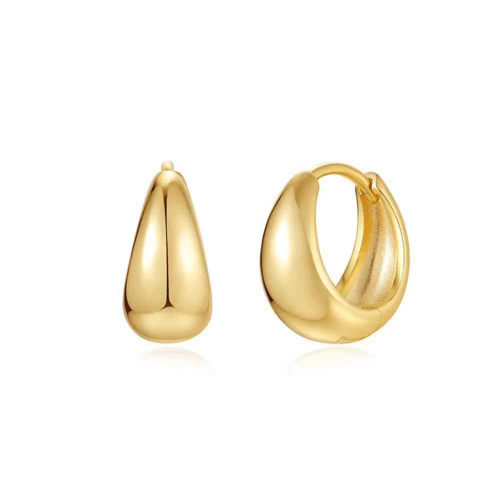A pair of gold tone geometric earclip earrings with a round design and screw-back mechanism.