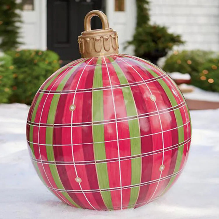 Large red and white striped inflatable Christmas ball ornament hanging on an outdoor tree