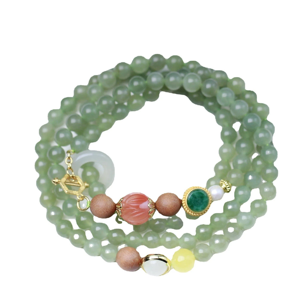 Hetian jade necklace with lotus beads, zodiac charm, and matching bracelet on white background