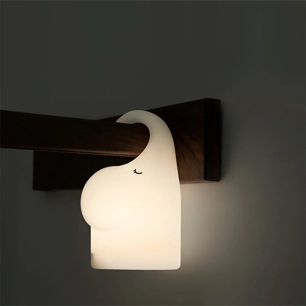 DOMI Elephant style silicone and plastic LED night light with warm white glow on a bedside table.