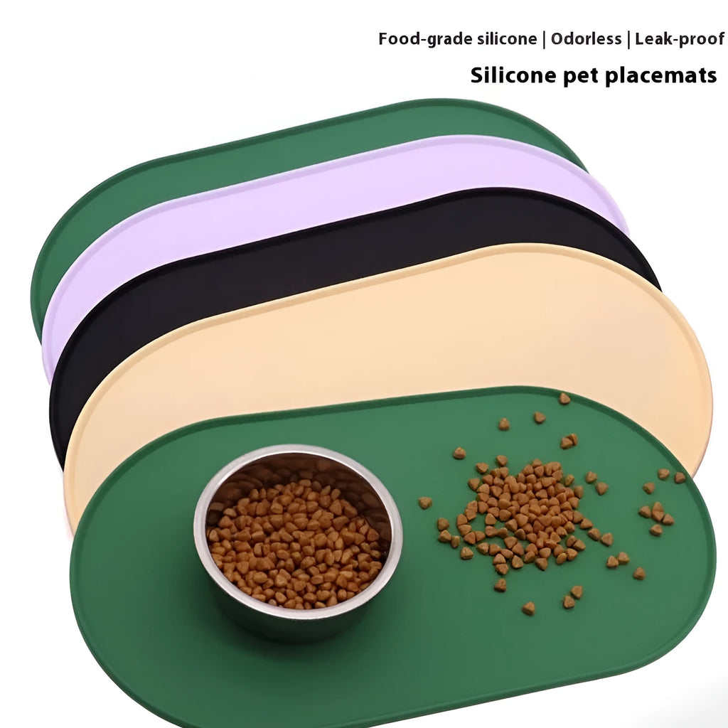 Green silicone cat feeding placemat on a floor next to a food bowl.