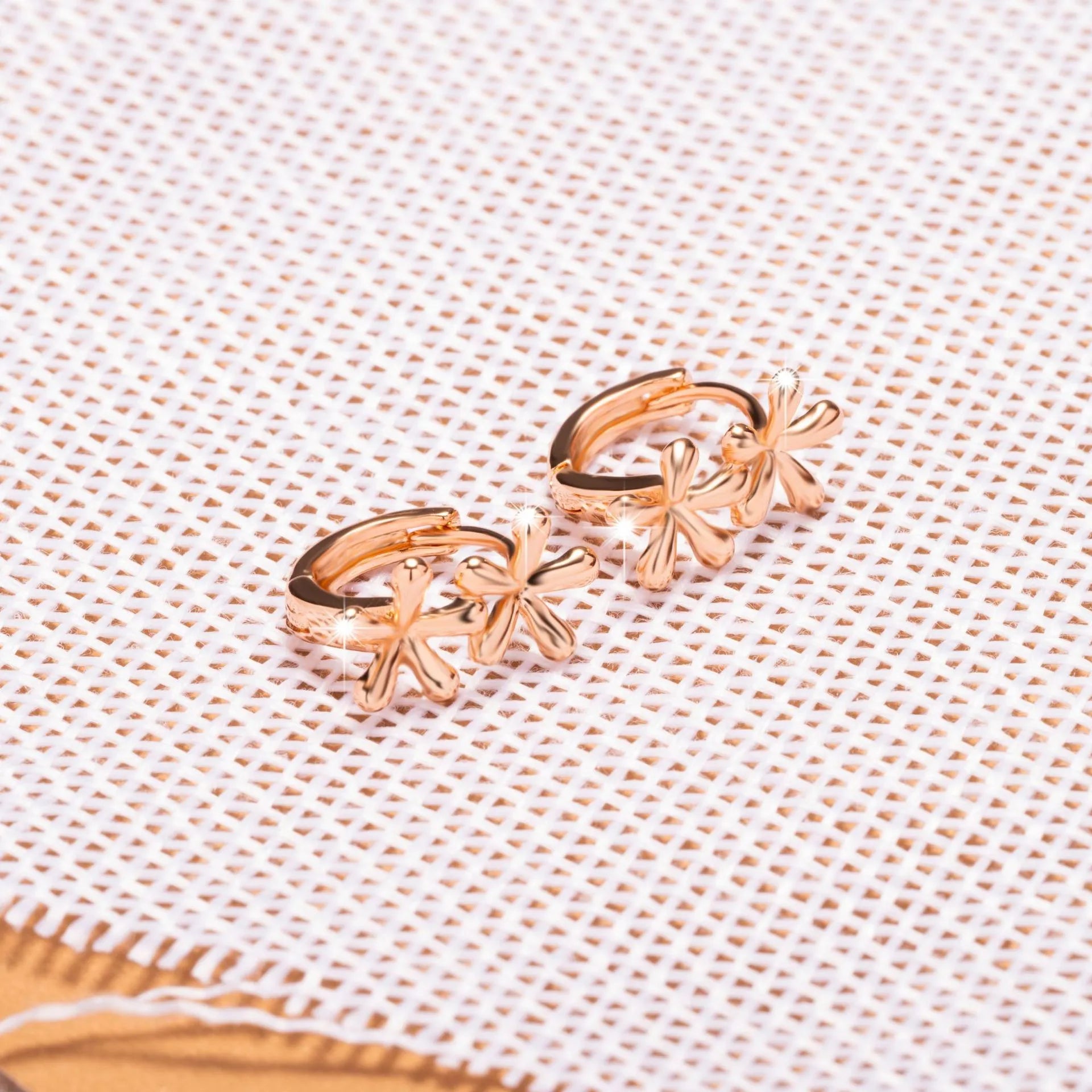 A pair of rose gold circular earrings featuring a waterdrop floral design with a fresh, sweet style.