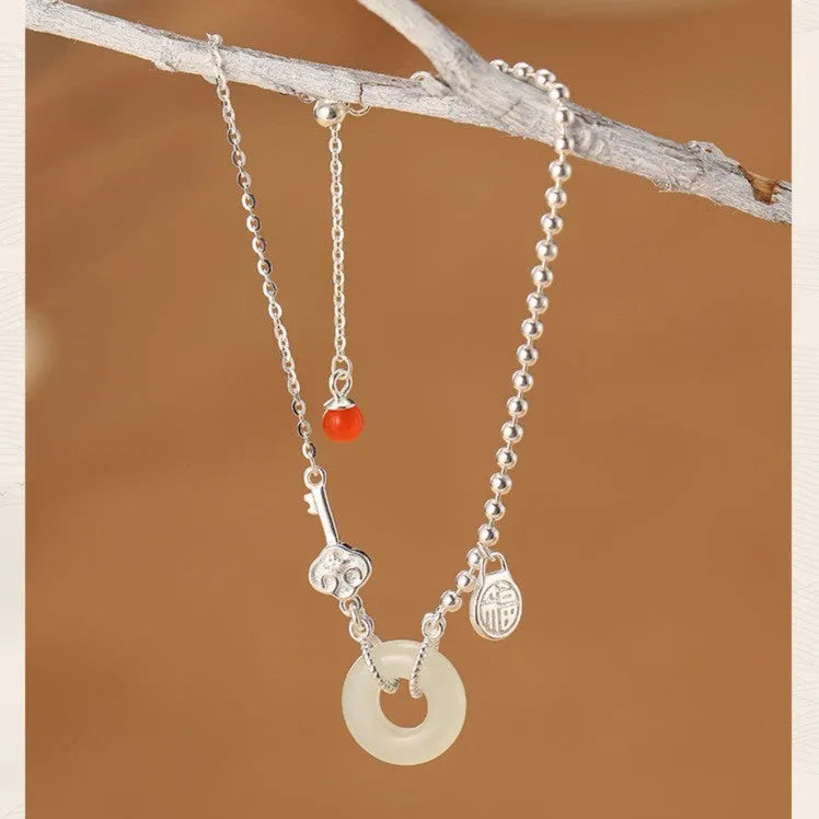 Women's silver bracelet with a geometric Hetian jade Wishful Blessings charm on a white background.