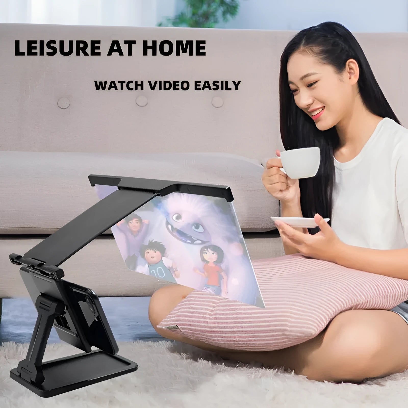 Black foldable mobile phone screen amplifier with detachable holder on a desk