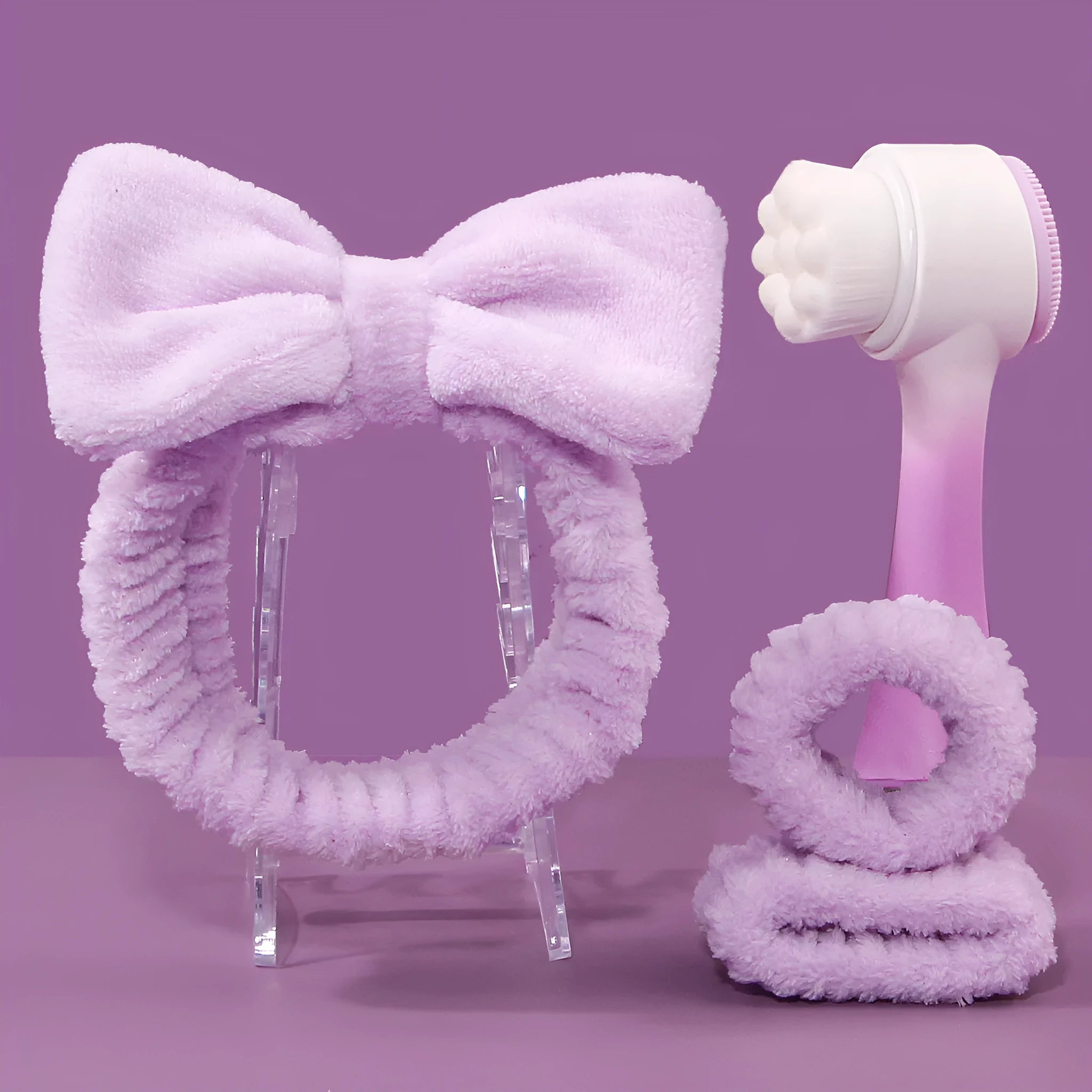 Facial brush and coral fleece hair band set in purple, grey, white, and pink colours.