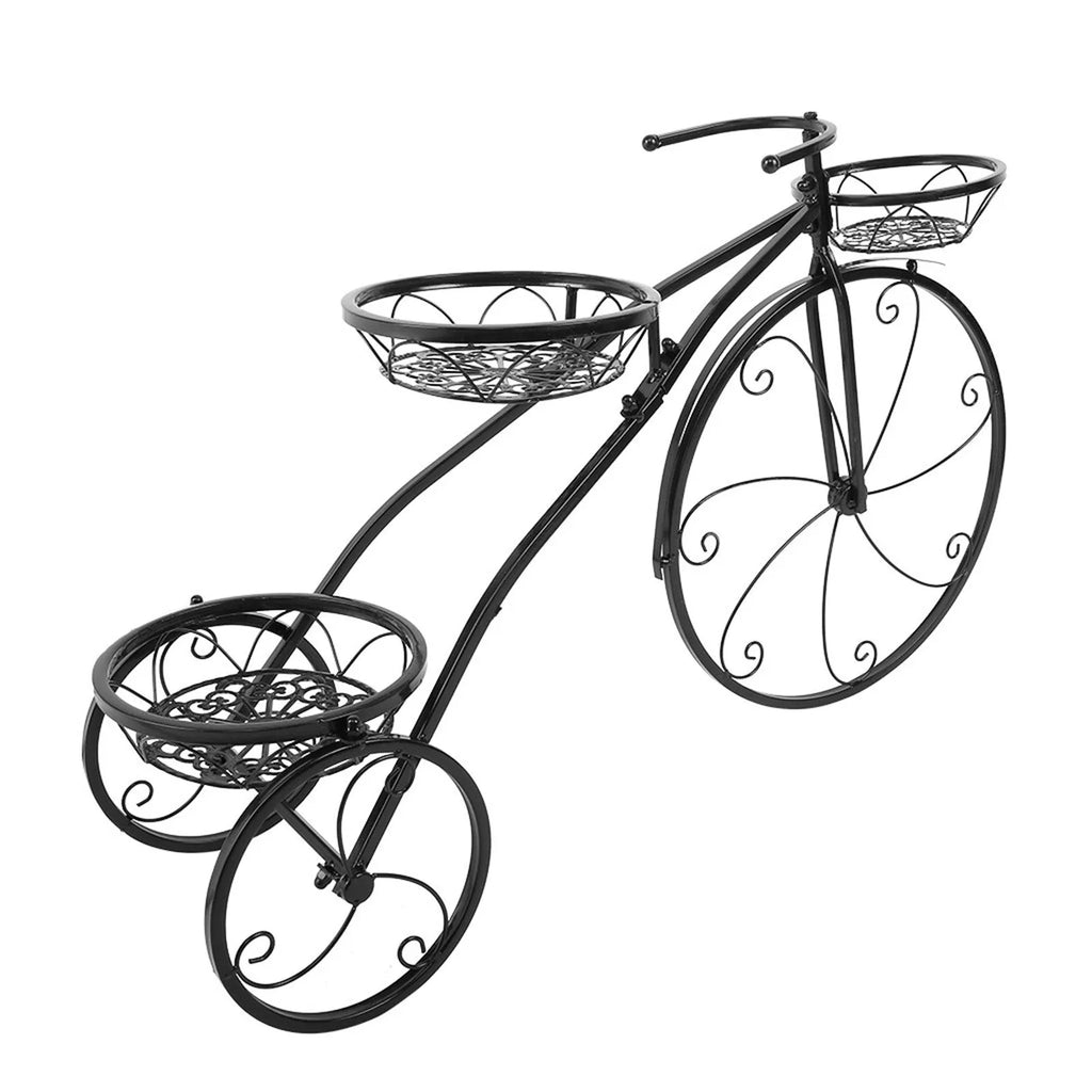 Black wrought iron tricycle plant stand with three round baskets holding small potted plants on a patio