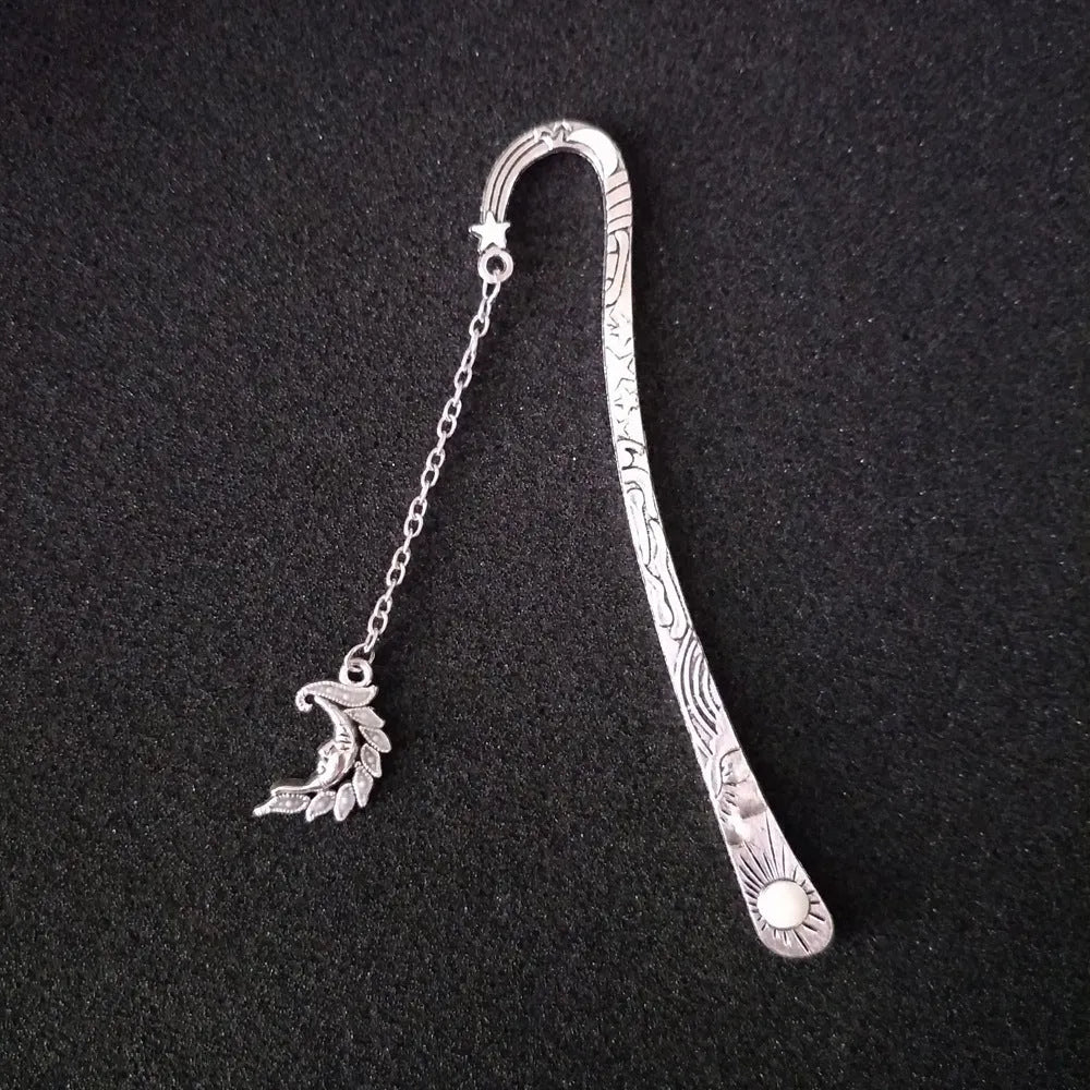 Metal bookmark with glowing five-pointed star and celestial sun moon stars design