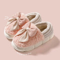 Big bow-knot fluffy slippers with covered heel in pink colour on floor
