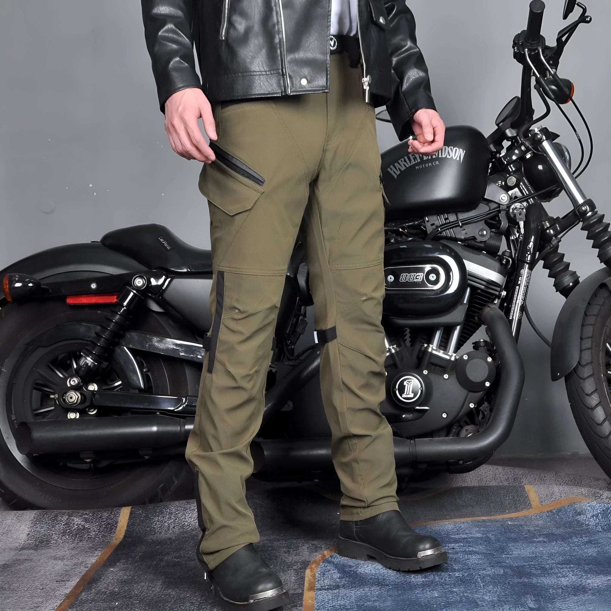 Men's green waterproof motorcycle cycling trousers with belt and protective gear on hanger.