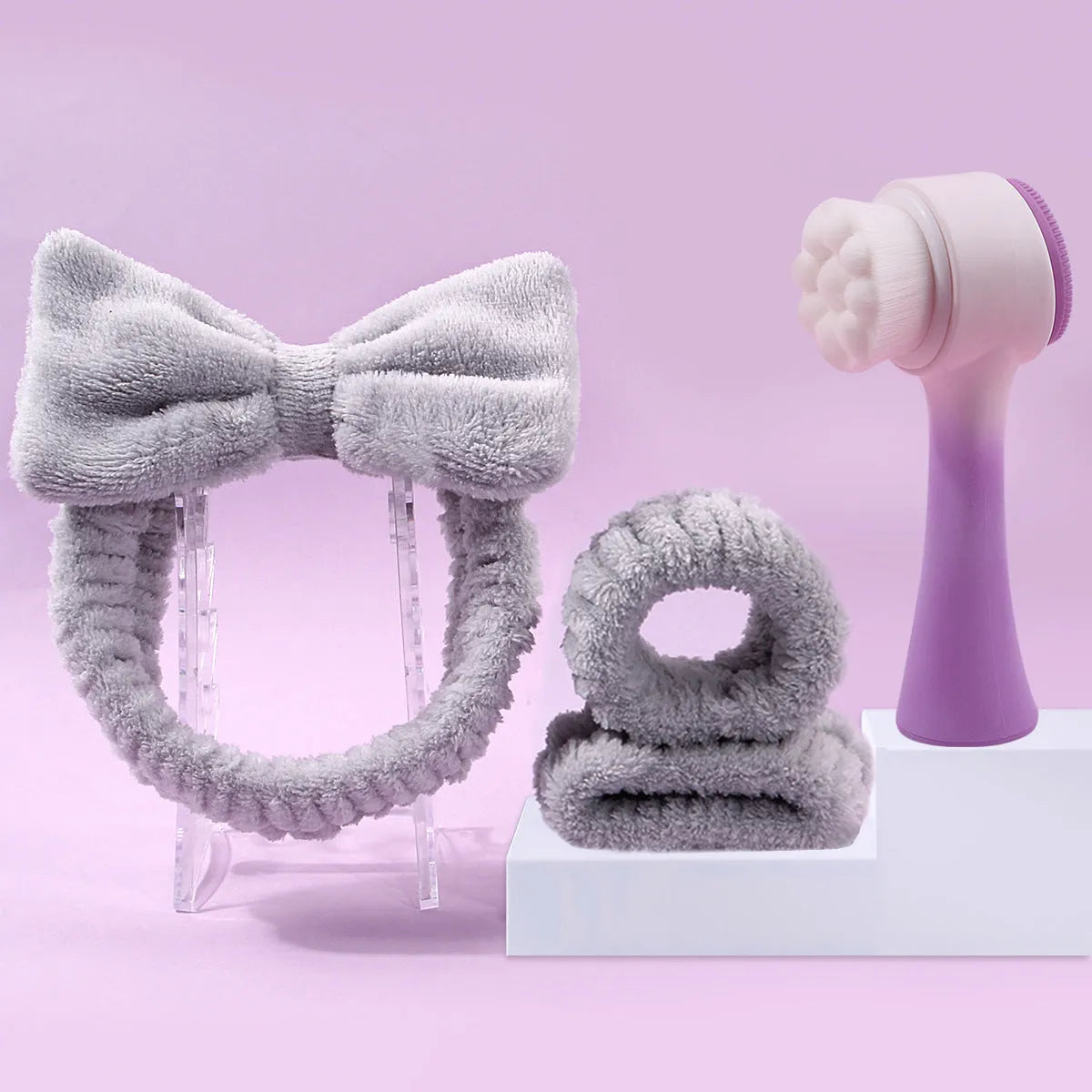 Facial brush and coral fleece hair band set in purple, grey, white, and pink colours.