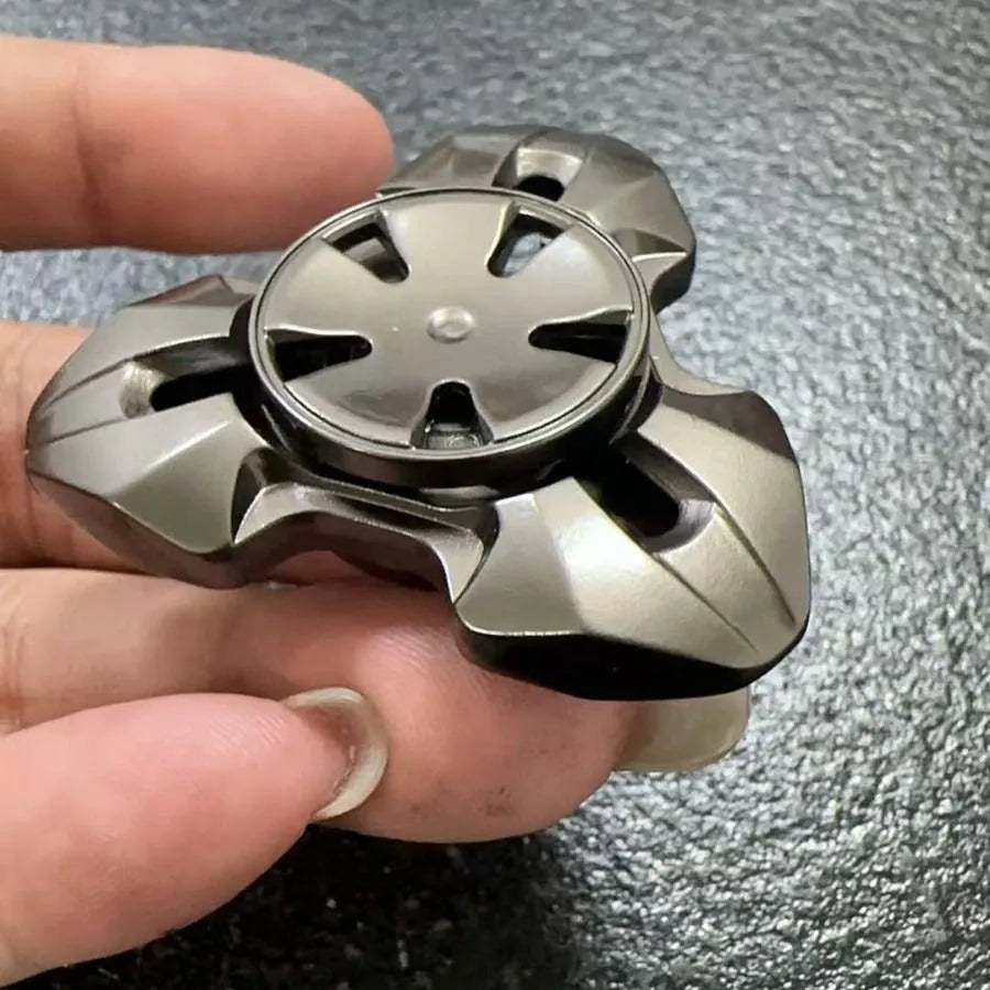 Close-up of a metallic alloy rotating fingertip gyro decompression toy on a table.