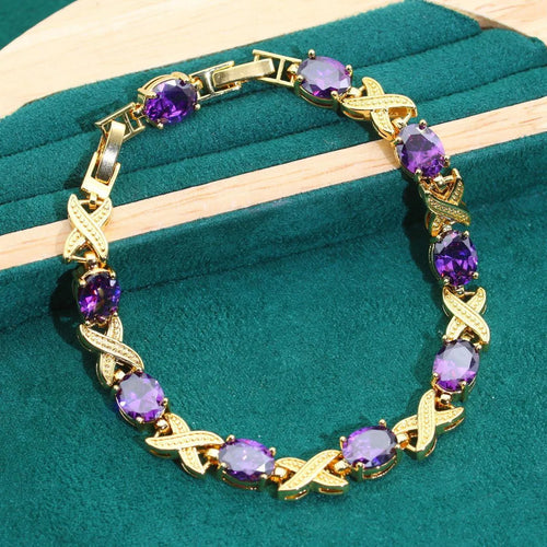 18k gold plated jewellery set showing ring, earrings, bracelet, and necklace with coloured cubic zirconia stones