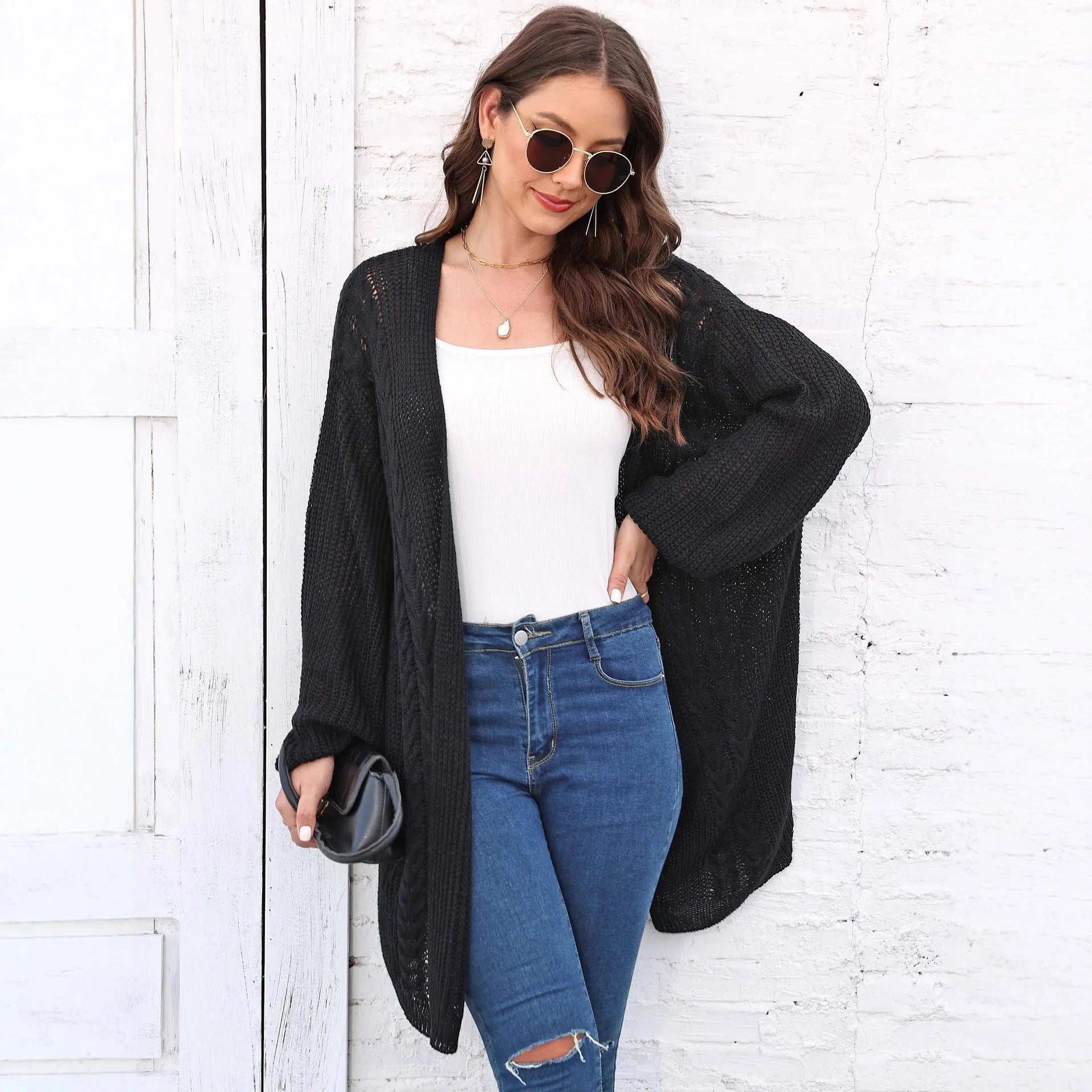 Women's loose fit acrylic sweater coat in a solid colour, shown on a hanger.